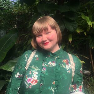 Photo of Stephanie, wearing a green shirt with flowers , with short blond hair
